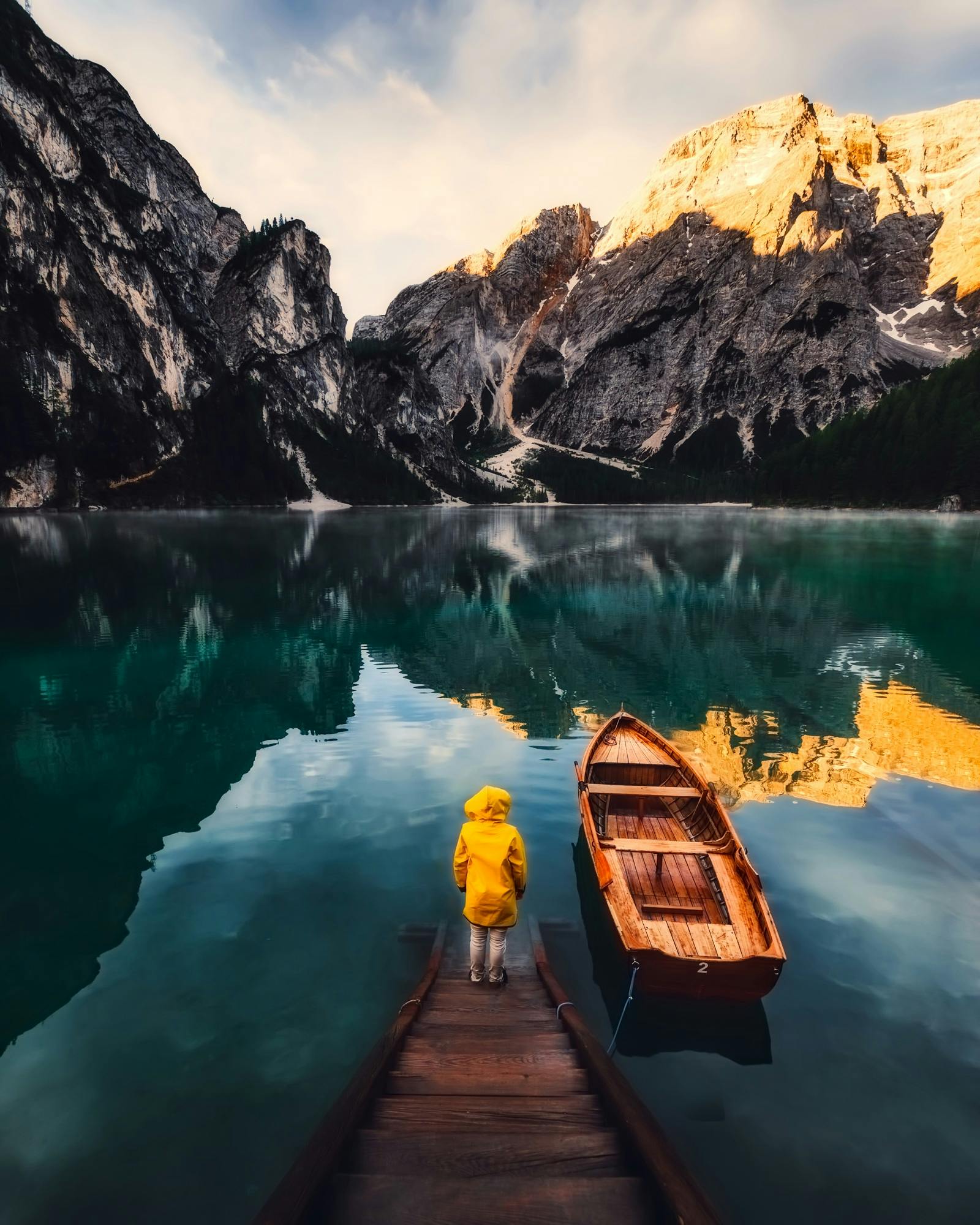 A peaceful lake surrounded by mountains with a dock and boat, perfect for adventure and reflection.